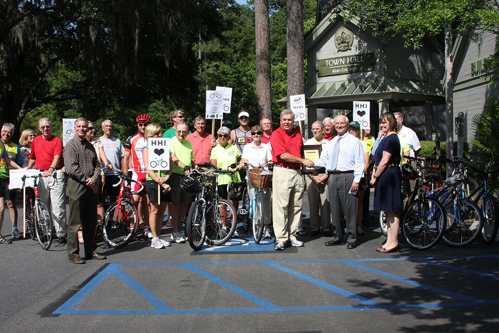 Mayor Laughlin presenting proclamation to group of cyclists outside Town Hall